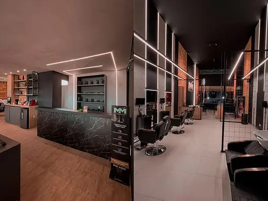 Salão da M&M Barber Pub com cadeiras e iluminação em linhas